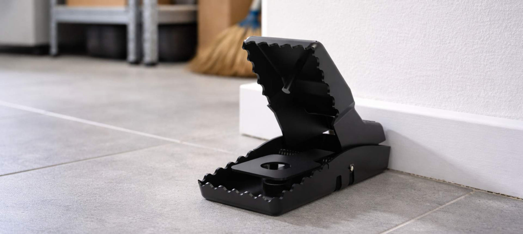 Piège à rat à mâchoire noir positionné dans un garage - article comment se débarrasser des rats SPARIL