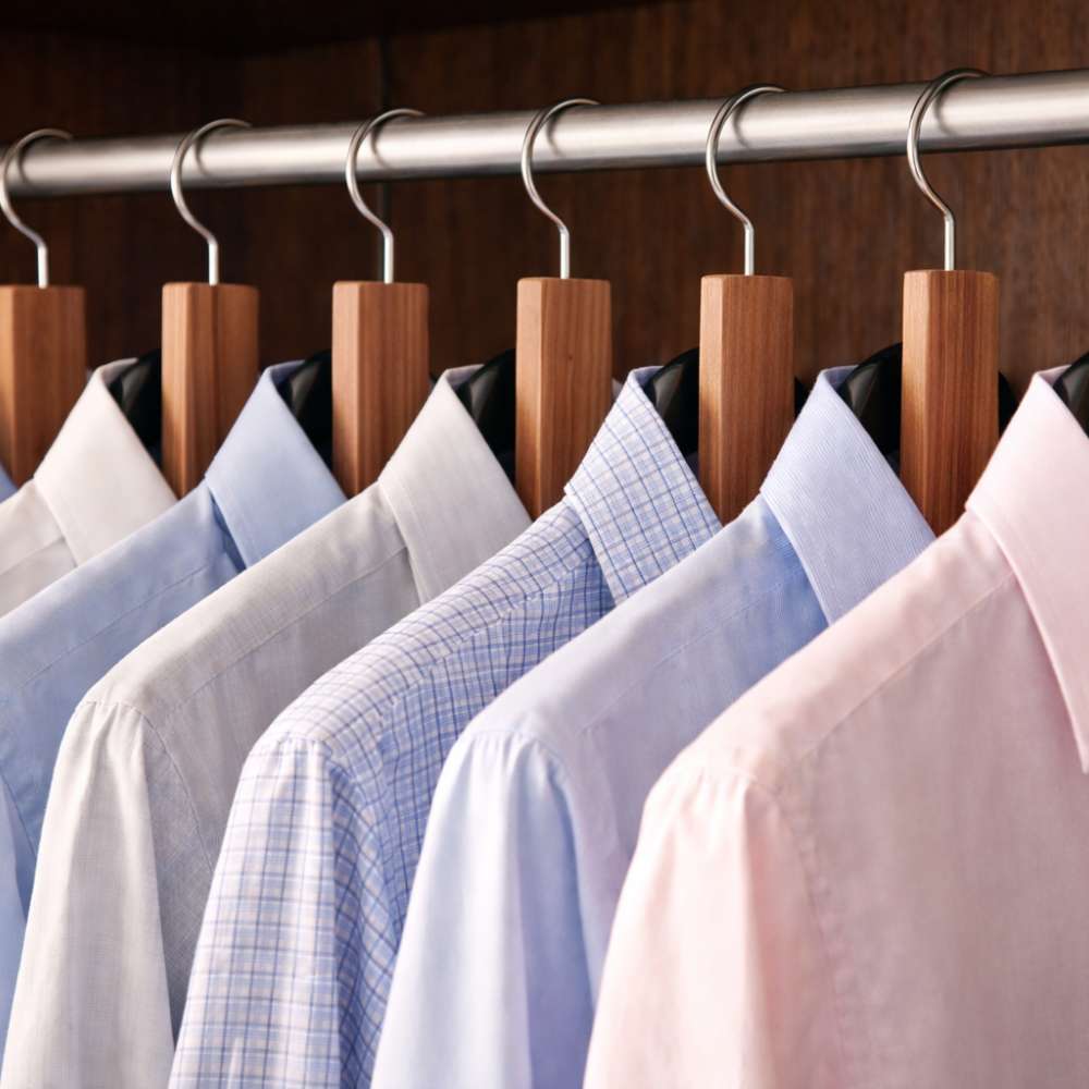 Plaquettes de cedre anti mites suspendues sur tringle de penderie entre chemises